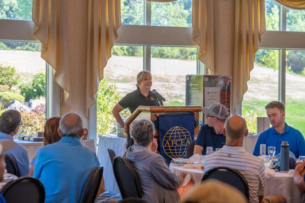 Erin Schubmehl welcomes the golfers at the post-tournament luncheon in September.