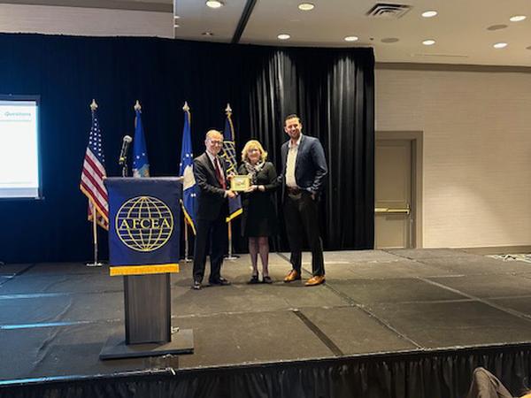 Wert is presented a token of appreciation by Chapter President Erin Donlan and Chairman of the Board Pat Hamilton at the May event.