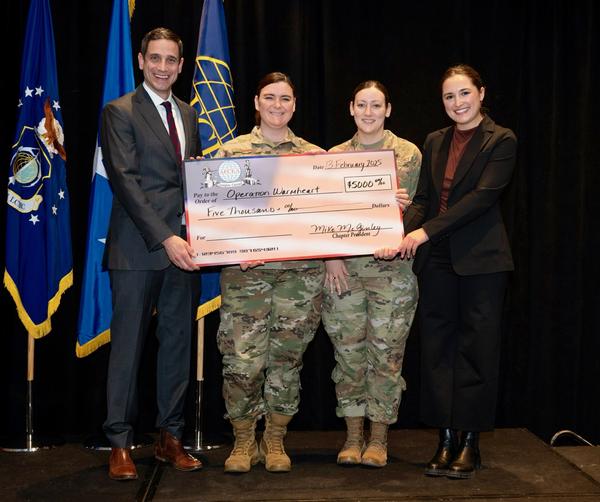 McGinley and Jaclyn Wilson present a check for Operation Warmheart during the February event. 