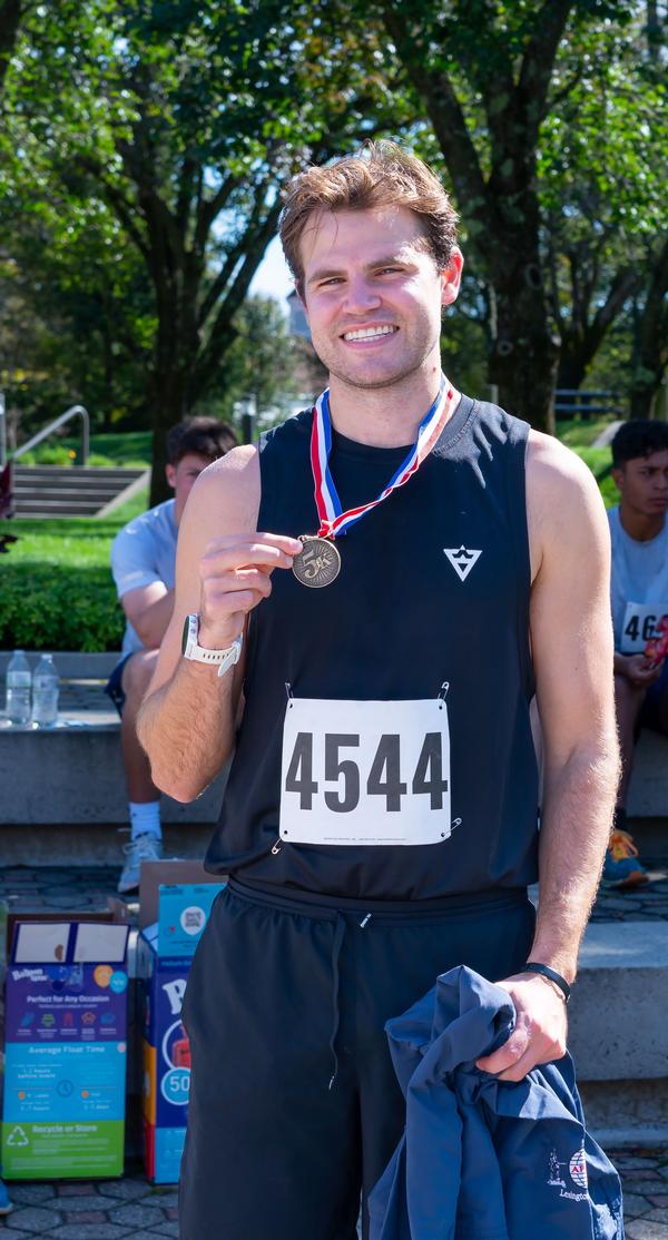 Men's winner Shane Gagnon shows off his medal following the September STEM 5K Fun Run.