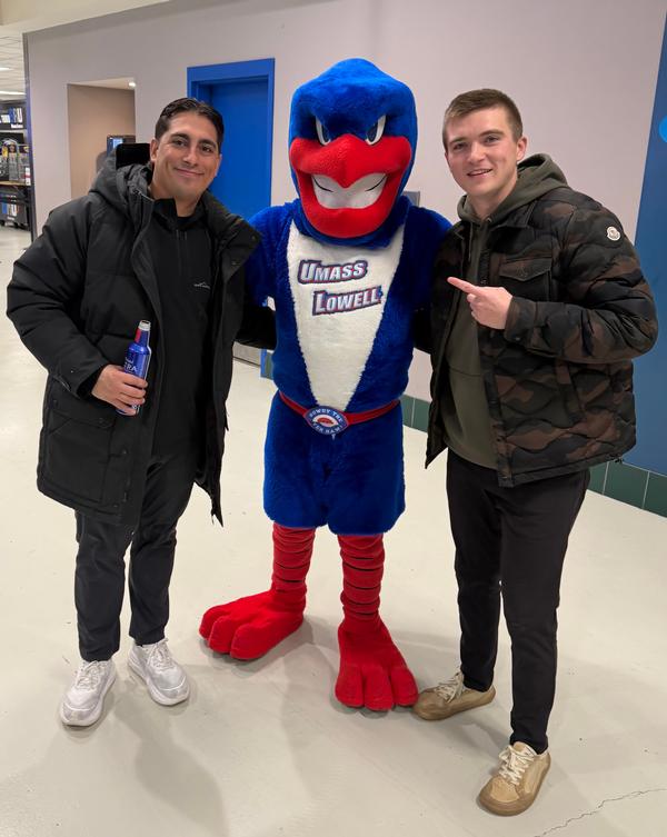 UMass Lowell's Mascot, Rowdy the Riverhawk with Emerging Leaders Alex Passafiume and Riley Smith enjoying the January game. 