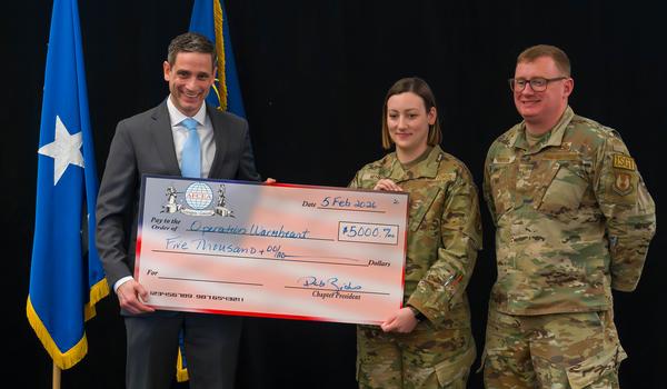 Mike McGinley, chapter chairman (l), presents a check for Operation Warmheart during the February event.