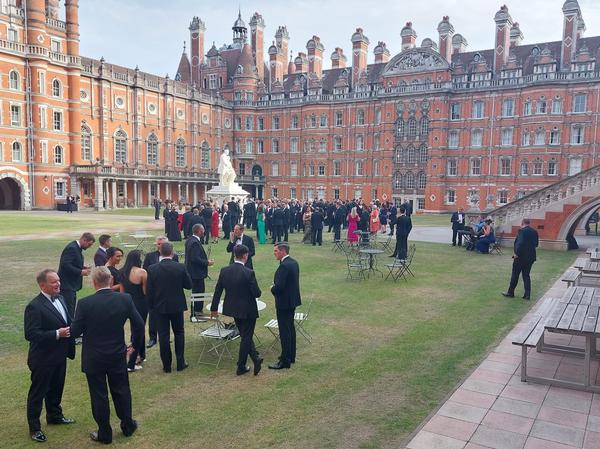 Attendees enjoy a pre-dinner drinks reception in the magnificent setting of Royal Holloway's Founders' Building South Quad in June.