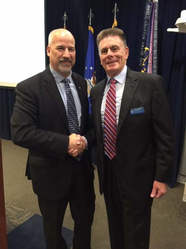 Dan Mathews, program support and business development, ENSCO, receives the Meritorious Service Award from Regional Vice President Adam Feingold at the June event.