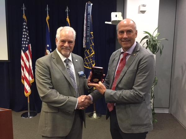 Chapter President Bill Page (r) receives the AFCEA Medal of Merit from Holker in July.