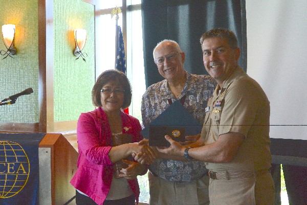 Cmdr. Martin Sabel, USN (r), chapter president, presents Rick Markle, chapter treasurer, and his wife Sadako with a farewell certificate and traditional Latte Stone replica in September.