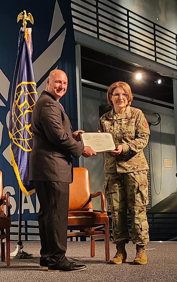 Chapter President Col. Thaddeus "Firewire" Janicki, USAF, presents a coin and certificate to Lt. Gen. Mary F. O'Brien, USAF, deputy chief of staff for Intelligence, Surveillance, Reconnaissance and Cyber Effects Operations, in May.
