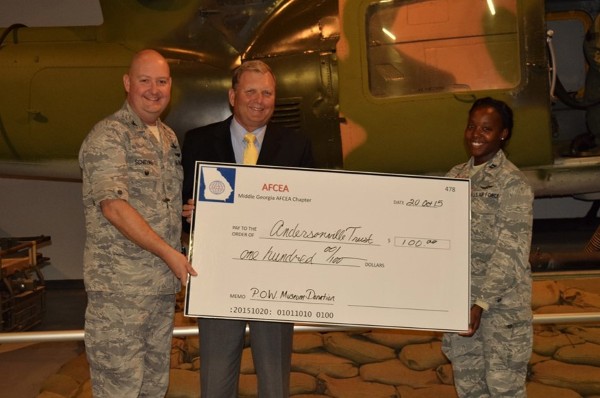 Chapter President Col. David Schilling, USAFR (l), and Capt. Gina Evans, vice president, publicity, present a check at the October event to the National Prisoner of War Museum in Lt. Gen. Michael Peterson's (c) name.