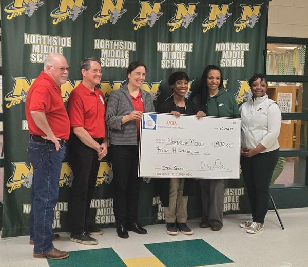 In March, (from l-r)  Gillis, Frost and Darveau present faculty from Northside Middle School, Terra McMillan, STEM teacher, Alma Munday, principal, and Trathenia Evans, assistant principal, with an award check.