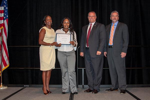 Stokes (l) presents Alabama State University student Tawana Fuller a scholarship, with assistance from Aldridge (2nd from r) and Knott, at the May luncheon.