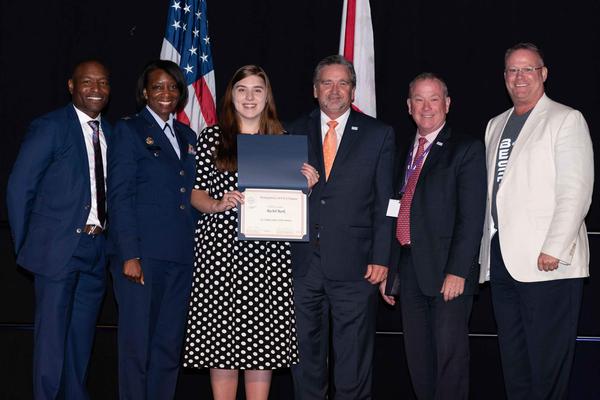 At the May luncheon, Rachel Rook, High School Information Technology Summer Internship Program Scholarship recipient (c), poses with (l-r) Eric Sloan, Education Foundation director, Col. Kyna McCall, USAF, chapter president (second from l), Brian Knott, Array; Axel Foley, Array; and Richard Aldridge, program executive officer (PEO) Business Enterprise Systems (BES).