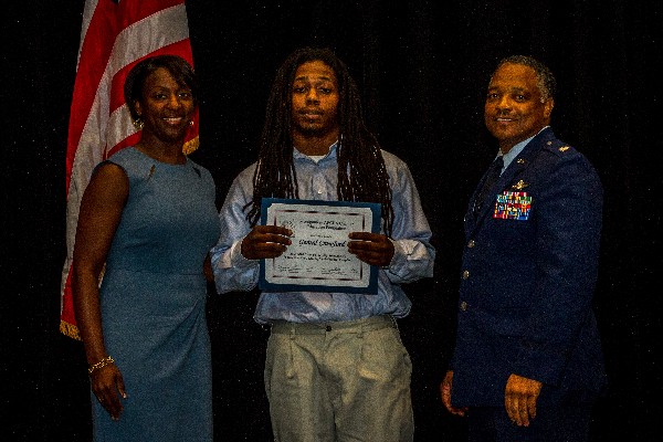 Gerard Crawford (c), a rising senior at Troy University, accepts his Education For Industry scholarship presented by Stokes (l) and Lt. Col. Boothe in May.