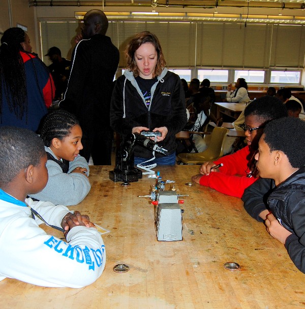 An Alabama State University student volunteer demonstrates how to use a robotic arm during a Robotics mini-camp session in February.