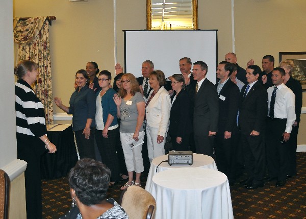 Jane Brightwell, AFCEA regional vice president (l), installs the chapter's leadership team for 2014-2015 in August.  Although not all pictured here, the new team includes 28 leaders.