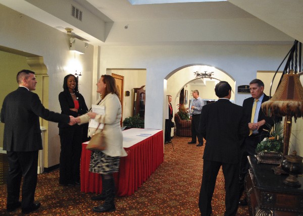 Mike Warlick, AFCEA International vice president of defense operations (far r), and chapter members network before the November luncheon.