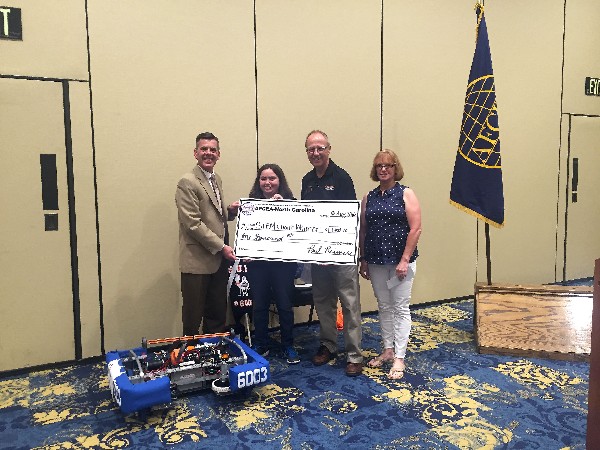 Reimers (l) and Popp (r) present a $1,000 check in August to the Harnett County FIRST Robotics Team, represented by team member Lydia Gutierrez and Steve Hasselberg, Campbell University engineering lab manager and alternate lead mentor for the team.  
