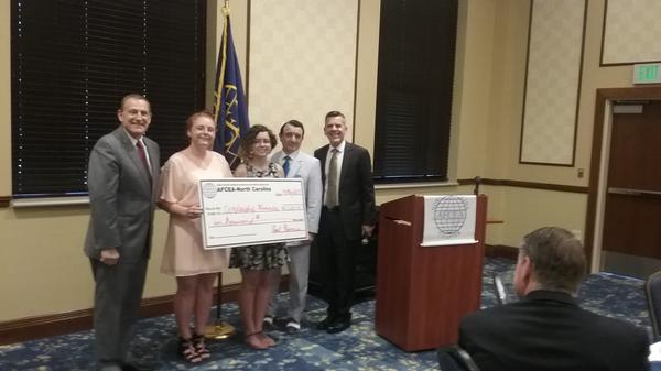 Gen. Basla (l), Trini Capelo, chapter vice president (2nd from r), and Paul Reimers, chapter president, present scholarships to Emily Van Hoozer (2nd from l) and Hannah Stanton in June.