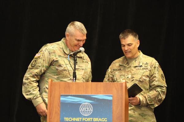 Major Gen. Peter Gallagher, USA, director of the U.S. Army's Network Cross-Functional Team (l), keynote speaker at TechNet Fort Bragg in April, accepts a token of appreciation from Brig. Gen. Todd Isaacson, USA.