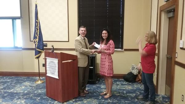 Reimers presents a science, technology, engineering and mathematics (STEM) grant to Kelly Osornio of Eastover Central Elementary School (r) in September as Georgia Popp, chapter STEM coordinator, looks on.