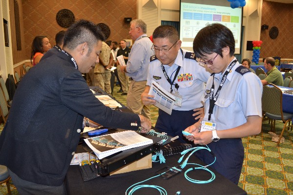 Shuichi Katakura (l), regional sales manager for Japan, The Siemon Company, demonstrates the use of fiber optic products to Lt. Col. Nobuhito Ide, Japan Air Self Defense Force (c), commander, 56th Aircraft Control and Warning Group, Japan Air Self Defense Force. Col. Ide has also become an AFCEA Life Member and was presented his certificate and pin during the October event.