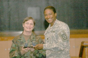 Lt. Col. Maria Drew, chapter president, presents Capt. Buckles with a gift in appreciation for her guest presentation in April.