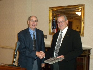 Col. Fred Eisele, USA (Ret.) (l), chapter vice president for programs, presents memento to Pete Marion, assistant program executive officer for customer support, U.S. Army Program Executive Office for Simulation, Training and Instrumentation, following his speech in March.