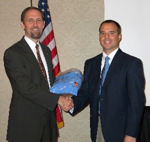 Dr. Roger Smith (l), chapter president, presents a token of appreciation to Shaun Schneider, who was recognized as the chapter's AFCEAN of the Quarter at the October meeting.