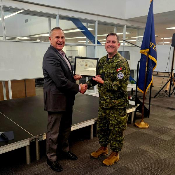 Crosby receives a certificate from Chapter President Walter Wood at the December event.