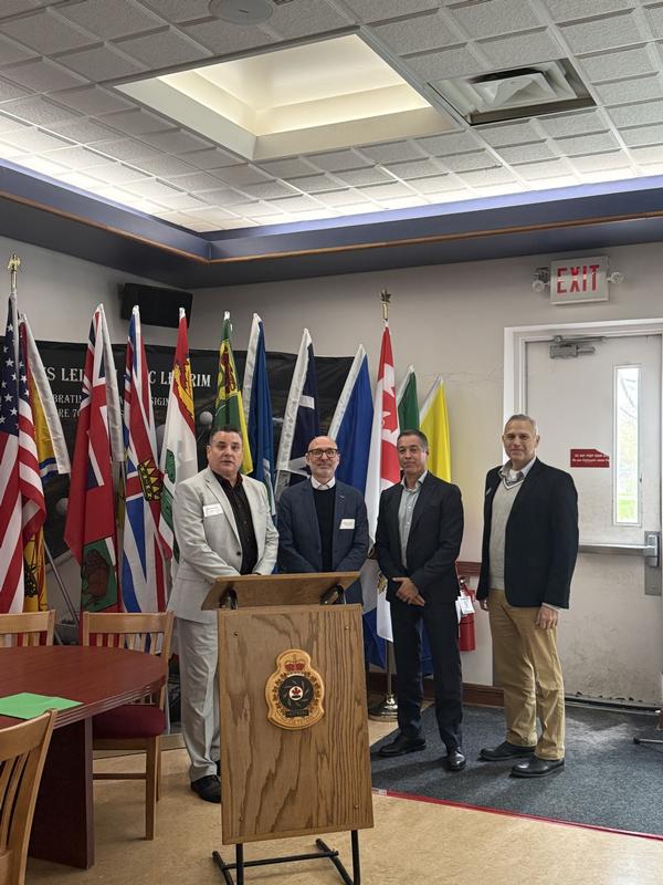 Wood poses for a photo with Hebert and representatives from the May luncheon sponsor, Fortinet.
