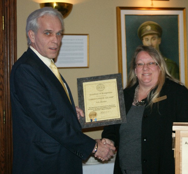 In February, Stewart presents a Lifetime Membership certificate to Christopher Szlamp.