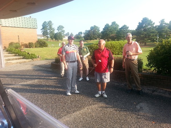 Maj. Gen. John Maluda, USAF (Ret.) (c), gives golfers in the July tournament the rules of engagement before hitting the course.