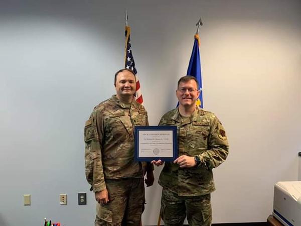 In July, Lt. Col. Richard Sharpe, USAF, chapter vice president (l), presents Col. Richard Brown, USAF, outgoing chapter president, with the AFCEA International Presidential Certification of Appreciation. 