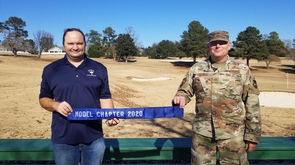 In December, Lt. Col. Richard Sharpe, USAF, outgoing chapter president (l), presents the Model Chapter Award to Col. Gary Cornn, USAF, new chapter president.  