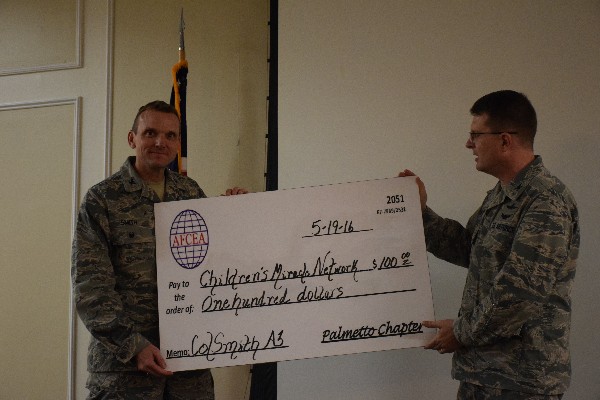 Col. Stamatis Smeltz, USAF (r), chapter president, presents Col. Smith with a $100 donation to his favorite charity, the Children's Miracle Network, from the chapter.  