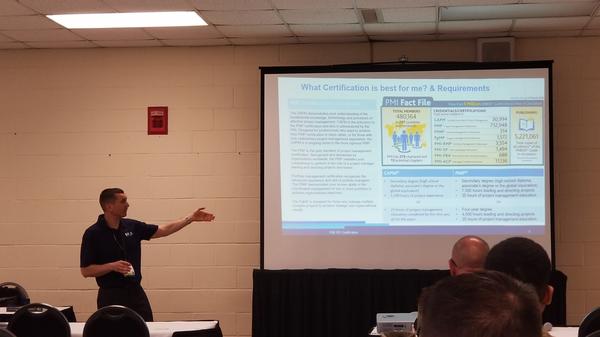 Lt. Col. Michael DeCicco, USA, of the Fayetteville PMI Chapter, speaks at the April symposium during a session about project management certification and how it can help transitioning military personnel. Chapter representative James Crawford also offered classroom support during this session.  