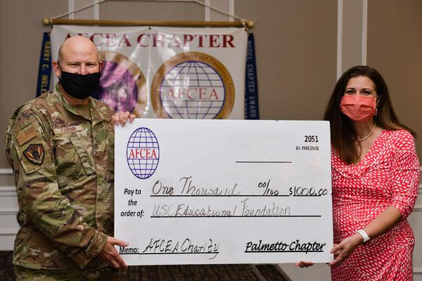 In August, Col. Cornn (l) presents $1,000 to the University of South Carolina Educational Foundation for STEM Education in the community.
