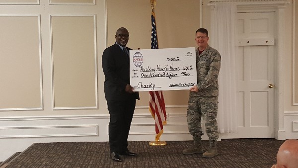 Gen. Brundidge (l) receives a check for $100 in his name for the charity Building Homes for Heroes from Chapter President Col. Stamatis Smeltz, USAF, at the October event. 

