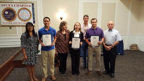 Surrounded by family members, three students each receive $1,000 scholarships at the May luncheon. They include (from l, holding certificates) Evan Moxley, Elizabeth Orban and Champ Newman, who will begin studying science, technology, mathematics and engineering disciplines (STEM) this fall.