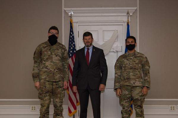 Gen. McCaffrey presents one-year AFCEA International memberships to Airman 1st Class Jacob Mackel, USAF (l), and Airman Aiman El Kadmiri, USAF (r), in May.