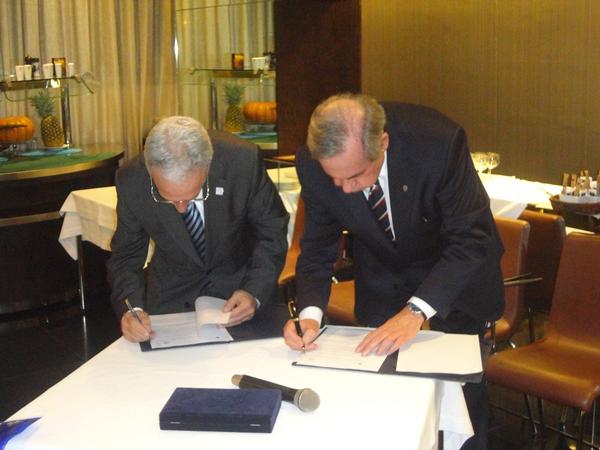 Adm. Durao (l) and Carlos Mineiro Aires, head of the Order of Engineers, sign a protocol at the February dinner.