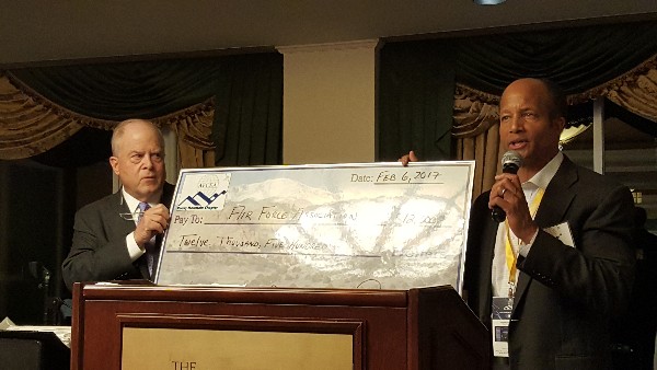 Col. Bob Wright, USAF (Ret.), chapter president (r), presents F. Whitten Peters, AFA chairman of the board and former secretary of the Air Force, with a $12,500 check to support the Wounded Airmen Program at a February charity event.