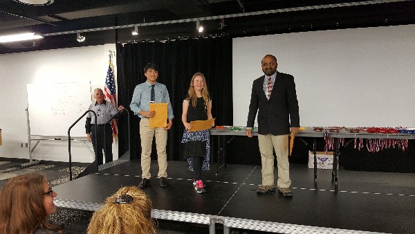 Srikant Mantravadi, chapter science fair chairman (r), presents awards to two student winners in February.
