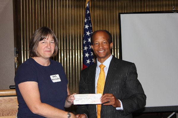 Col. Wright (r) presents Gail Whalen from the Peterson Air Force Base Air and Space Museum with a $1,000 check from the chapter during the September luncheon to help fund a science, technology, engineering and mathematics (STEM) facility.