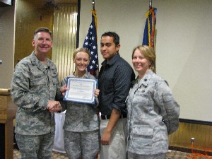 In May, Brig. Gen. David Warner, USAF (l), director, Communications and Information, and chief information officer, Headquarters Air Force Space Command, Peterson Air Force Base, Colorado, presents a $1,500 scholarship to Airman 1st Class Carrie Ferrer, USAF (2nd from l), as her husband, David Ferrer (2nd from r), and her commander, Lt. Col. Tara Routsis, USAF, look on.
