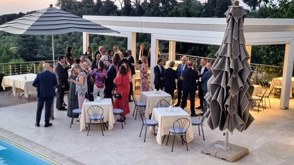Attendees enjoy the traditional July midsummer dinner while congregating around the swimming pool.
