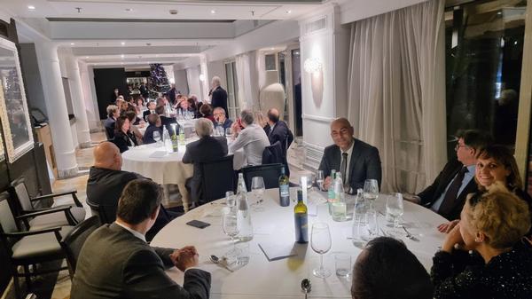 Dinner guests exchange cheer and seasons greetings at the December dinner in Rome. 
