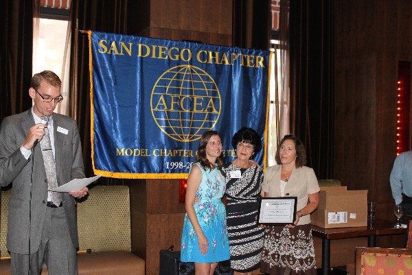 Chapter President Jesse Hamilton (l) announces the inaugural Jim Loiselle Volunteer of the Year Award, which was presented with Loiselle's daughter (2nd from l) and widow (c) to Lillian Maestas at an August event.