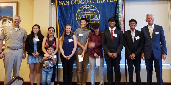 Rear Adm. Ronald Fritzemeier, USN, chief engineer, Naval Information Warfare Command (NAVWAR) (far l), and Dave Grundies, chapter chairman of the board of directors (far r), present STEM scholarships to eight students at the July luncheon.