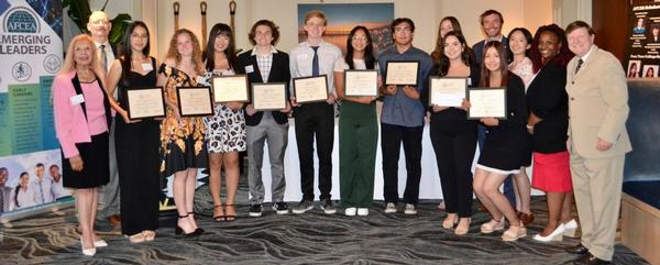 Scholarship recipients proudly display their scholarship awards during the August reception.