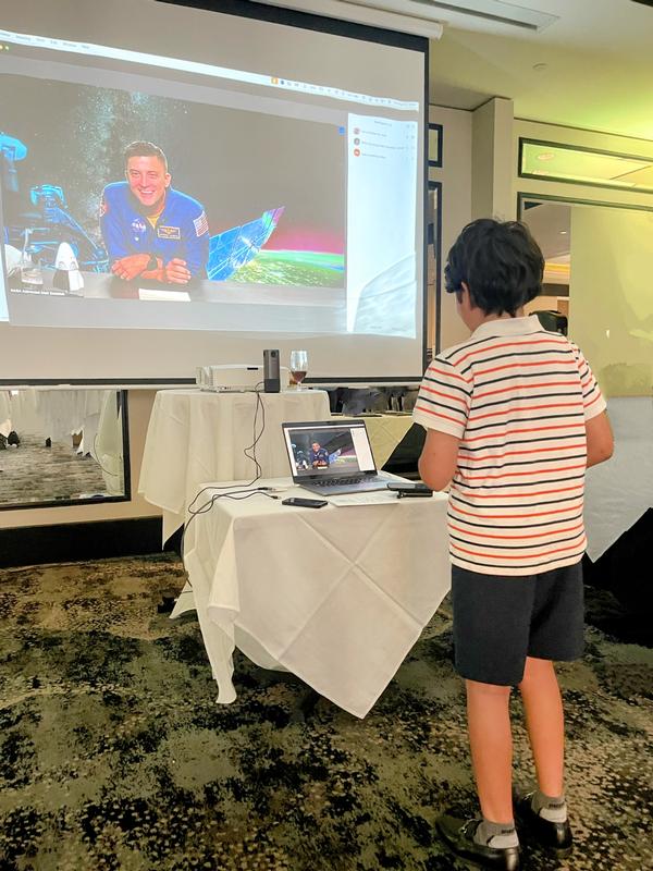 Ryan, 7th grade, brother to scholarship recipient, questions Matt Dominick, a NASA astronaut and U.S. Navy commander, in August. 